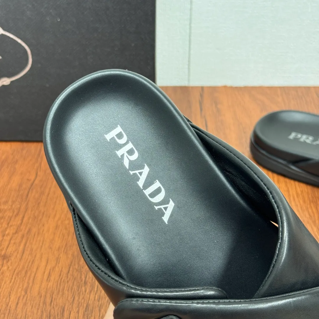Batch 580 Prada/Prada's new men's leather cross slippers. Velcro closure can finely adjust the size. Calf leather light luxury slippers. Thick soft calf leather wraps the upper. Fat but soft rubber lazy style, soft and comfortable, excellent foot feel. Genuine leather bottom layer, cross style, with a Velcro closure buckle, easy to adjust the appropriate size, and a perfect fit for the wearing experience. The enamel gold triangle logo highlights the brand's classic features. Lightweight rubber thin sole, high foot comfort! Complete package! Size: 39-40-41-42-43-44-45 Leather shoe size Item number: 2X7132 Black
